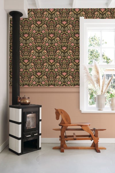 Wohnzimmer mit floral gemusterter Tapete, Kaminofen und Holzpferd