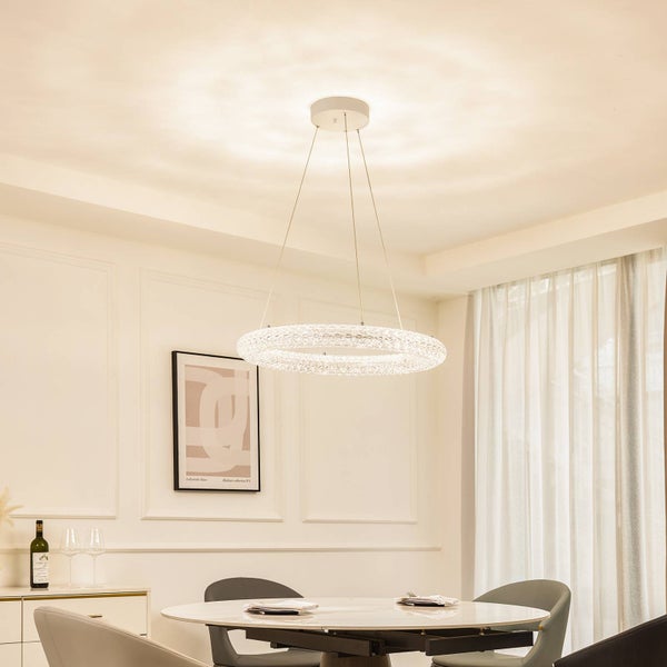 Moderne ringförmige Pendelleuchte mit Kristalleffekt über einem runden Esstisch in einem hellen eleganten Esszimmer.