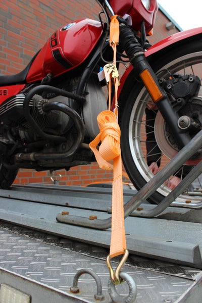 Motorrad auf Anhänger mit Spanngurt gesichert