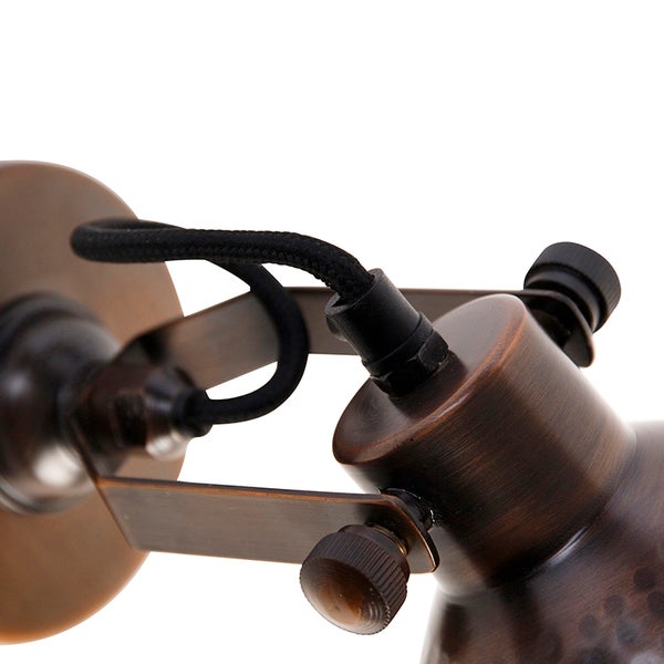 Detailaufnahme einer Wandleuchte mit Lampenschirm und Textilkabel