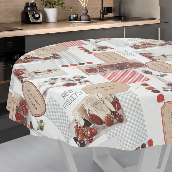 Rundtischdecke mit Beerenmotiven, Marmeladengläsern und Karomuster auf einem Tisch in einer modernen Küche mit Holzoberflächen.