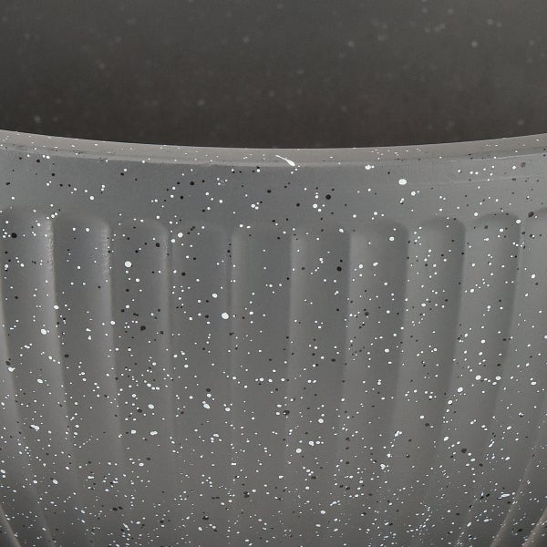 Nahaufnahme der Oberfläche eines Pflanzgefäßes mit vertikalen Rillen und gesprenkelter Textur.