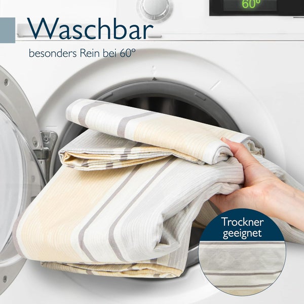 Gestreifte Bettwäsche wird in eine Waschmaschine gelegt. Waschbar bei 60 Grad und trocknergeeignet.