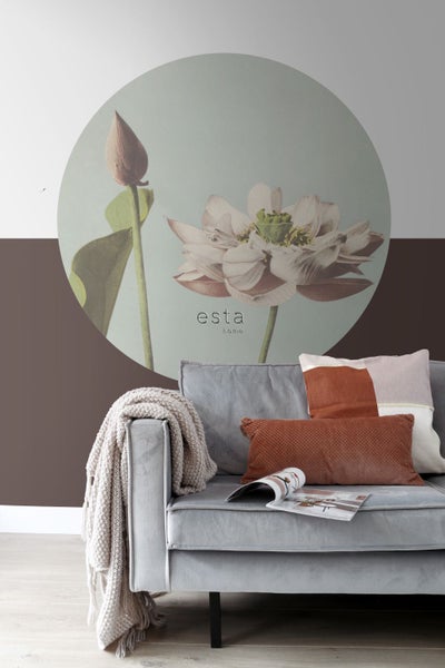 Wohnzimmerszene mit Sofa, Kissen, Decke und Wandbild mit Blumenmotiv