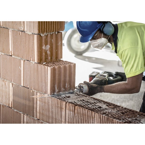 Mann sägt Ziegel mit einer Säbelsäge