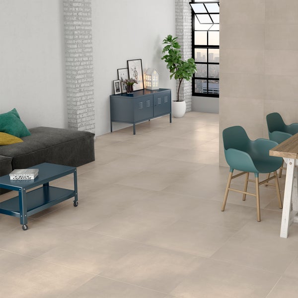 Modernes Wohnzimmer mit hellen Bodenfliesen in Betonoptik, blauem Sideboard, Sofa und grünen Stühlen in Loft-Atmosphäre.