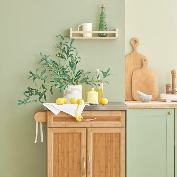 Küchenszene mit Bambuswagen, Olivenzweigen, Zitronen und Küchenutensilien