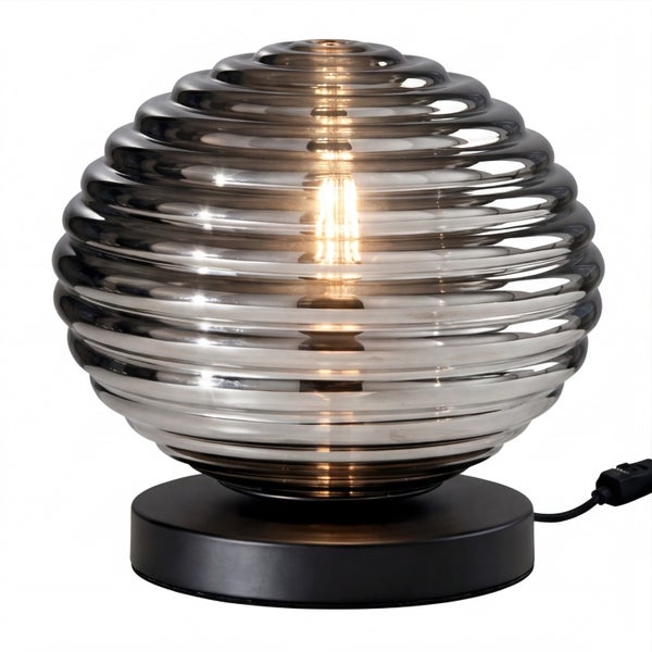 Tischleuchte mit geriffeltem Schirm aus Rauchglas und schwarzem Sockel.