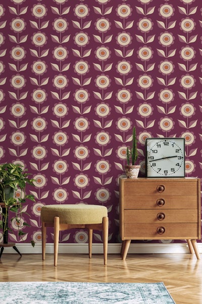 Retro-inspirierter Raum mit Blumentapete, Holzkommode und Sitzhocker
