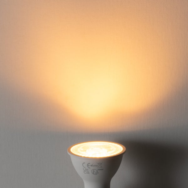 GU10 LED-Reflektorlampe mit warmweißem Lichtstrahl nach oben gerichtet. Symbole für Konformität und Entsorgung auf dem Gehäuse.