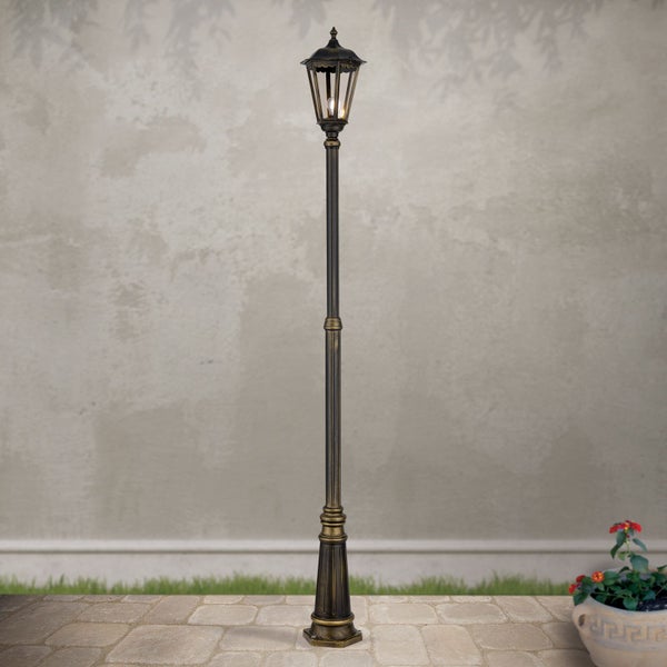 Traditionelle Außenleuchte als Kandelaber mit einem Lichtgehäuse auf einem hohen, verzierten Mast aus Metall.