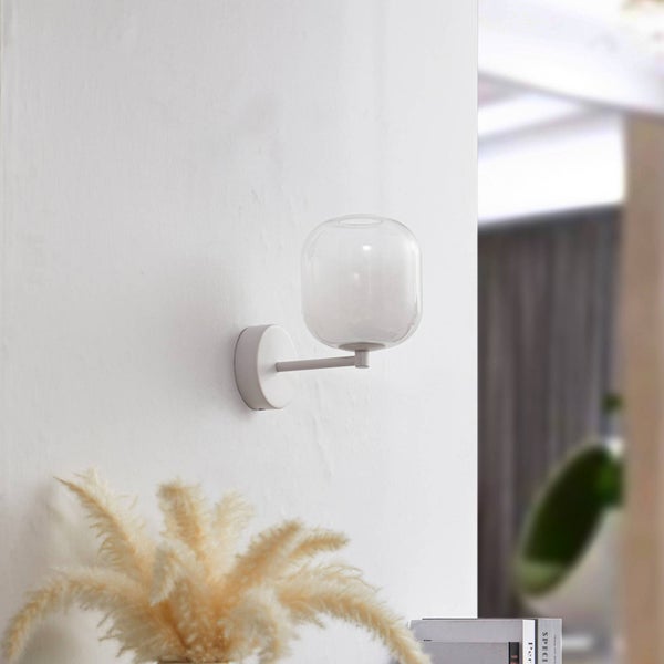 Moderne Wandleuchte mit rundem Glasschirm und weißer Halterung an einer weißen Wand montiert.