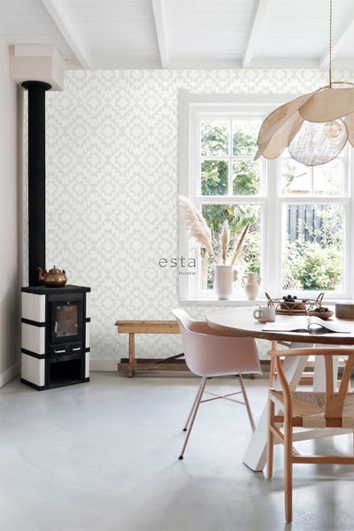 Heller Raum mit Ofen, Esstisch und gemusterter Tapete
