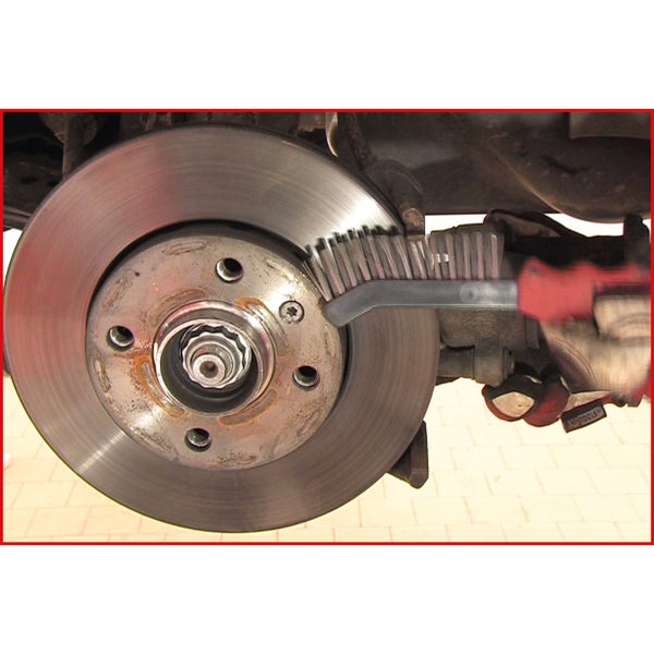 Eine Person reinigt eine Autoradbremse mit einer Drahtbürste.