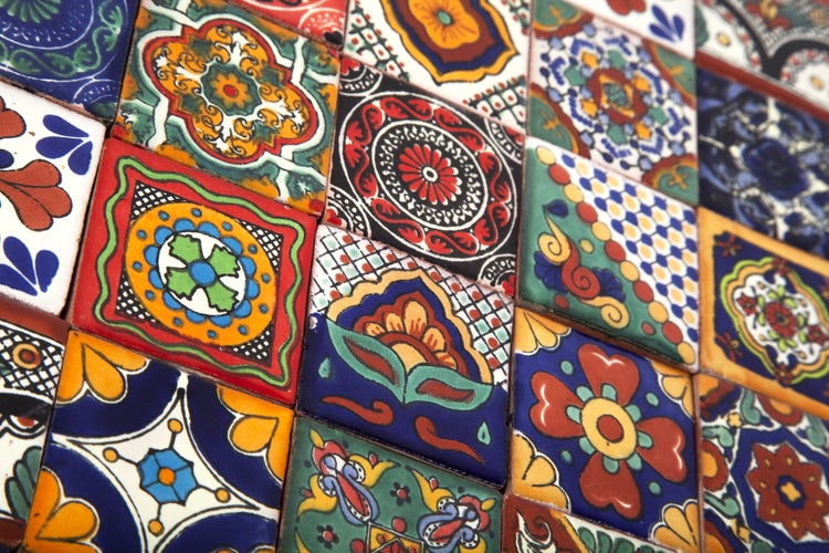 Dekorative Fliesen neben einer Tür und einem Lichtschalter an einer Wand.