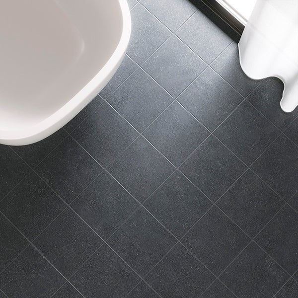 Quadratische Bodenfliesen in Steinoptik verlegt in einem Badezimmer mit Badewanne und Vorhang.