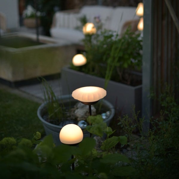 Beleuchteter Garten mit Solarleuchten im Blumenbeet