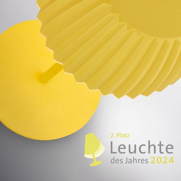 Wohnzimmer mit Sofa, Kissen in verschiedenen Texturen und Formen, Couchtisch und Beistelltisch mit Lampe