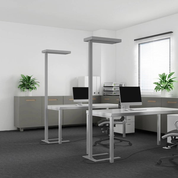 Modernes Büro mit zwei Arbeitsplätzen, grauen Schreibtischen und zwei hohen, minimalistischen Stehleuchten für optimale Bürobeleuchtung.