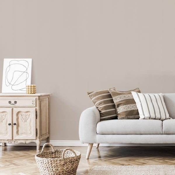 Wohnzimmer mit Sofa, Zierkissen, Holztisch und Korb