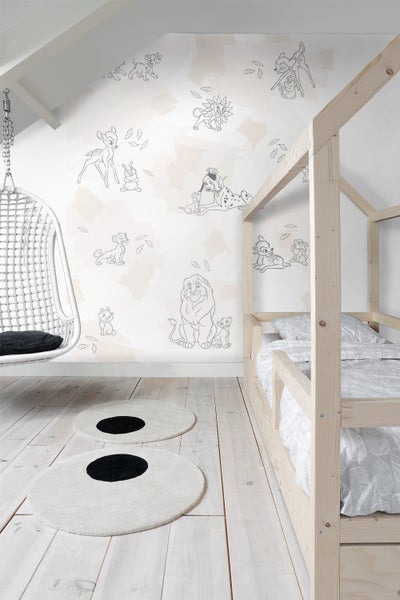 Kinderzimmer mit Himmelbett, Hängesessel und Teppichen mit Punktmuster vor einer Tapete mit Tiermotiven