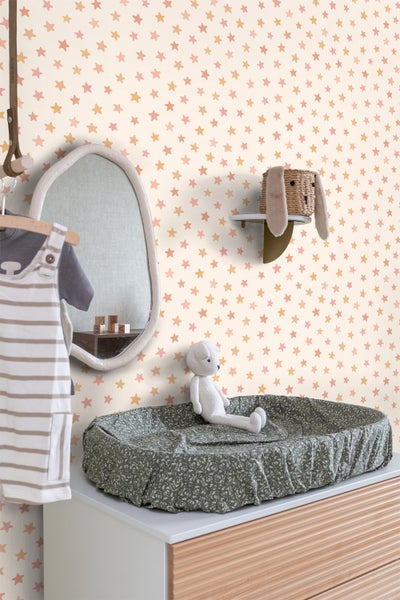 Dekoriertes Kinderzimmer mit Wickelkommode, Spiegel und Sternentapete