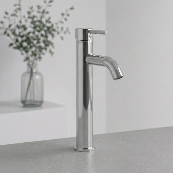 Hohe Waschtischarmatur in Chrom mit Einhandmischer auf einer grauen Fläche in einem hellen, minimalistischen Badezimmer.