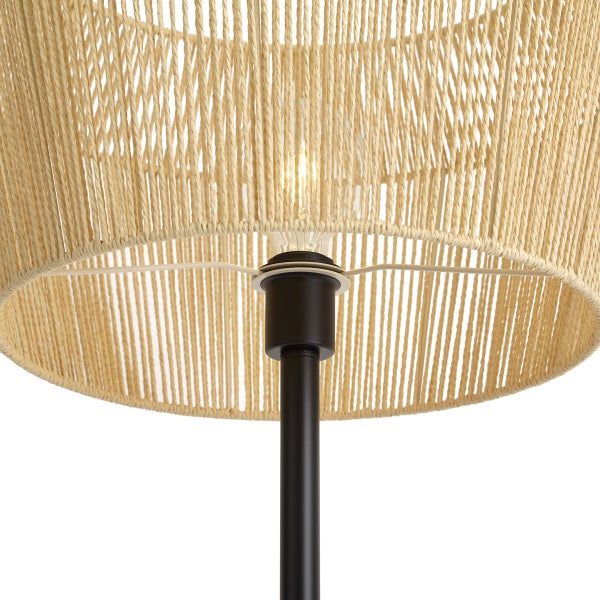 Nahaufnahme einer Lampe mit einem Schirm aus geflochtenem Seil, schwarzem Metallgestell und leuchtender Glühbirne.