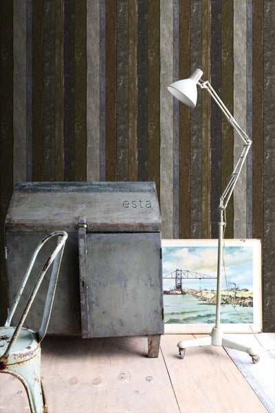 Einrichtungsbeispiel mit einer Tapete mit Streifenmuster, einer Lampe und einer Kommode