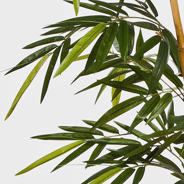 Künstliche Bambuspflanze mit grünen Blättern und naturgetreuen Halmen in einem schwarzen Kunststofftopf.