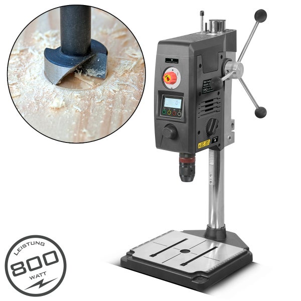 Tischbohrmaschine beim Bohren eines Lochs in Holz mit einem Forstnerbohrer. Leistungsstarkes Gerät mit 800 Watt Leistung.