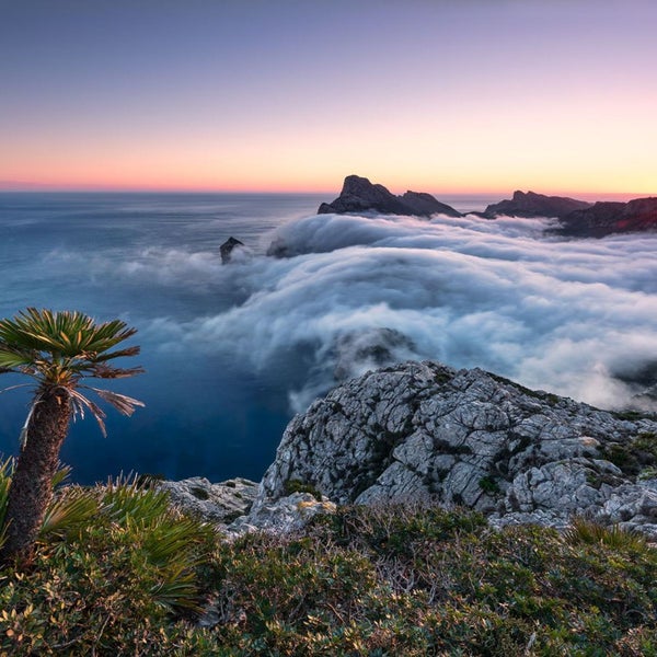 Landschaft mit Meer, Bergen, Wolken und Vegetation