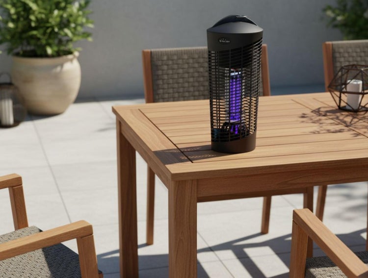 Elektrischer Insektenvernichter mit UV-Licht auf einem hölzernen Gartentisch in einer hellen Terrassenumgebung mit Gartenmöbeln.