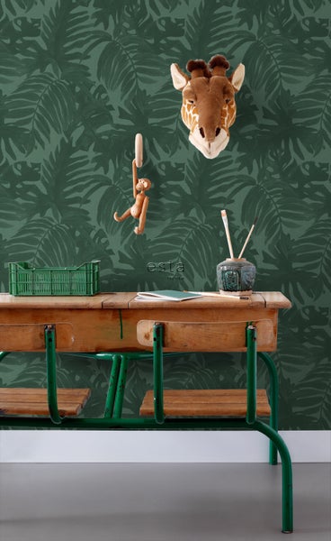 Dekoratives Zimmer mit grüner Blättertapete, Schreibtisch und Giraffenkopf