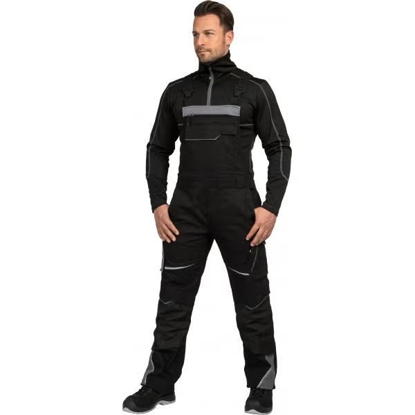 Schwarze Latzhose für Herren mit grauen Reflektoren, Brusttasche und verstärkten Kniepartien über einem schwarzen Langarmshirt.