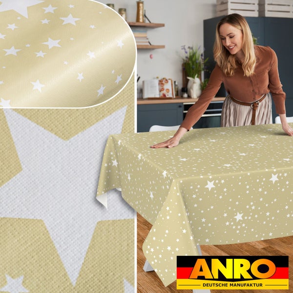 Frau breitet eine Tischdecke mit Sternenmuster auf einem Tisch in der Küche aus. Inklusive Detailaufnahme der Materialstruktur und ANRO Logo.