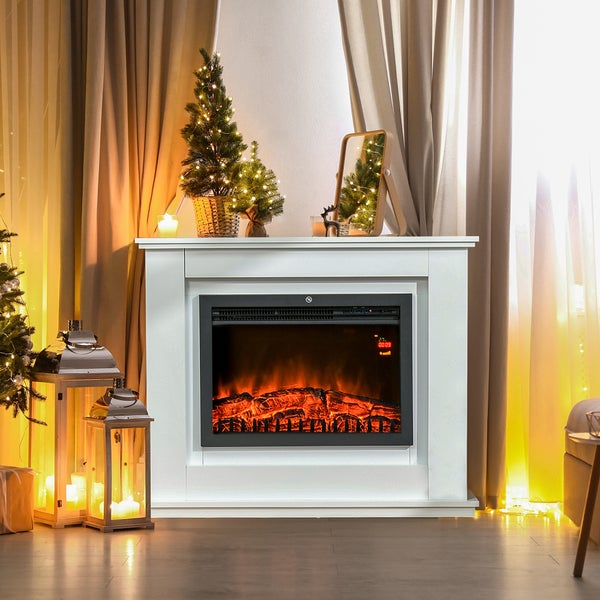 Moderner Elektrokamin mit weißer Umrandung in einem hellen, festlich dekorierten Wohnzimmer mit Laternen und kleinen Weihnachtsbäumen.