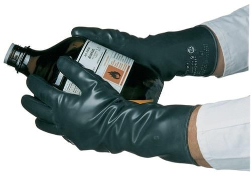 Hände in Chemikalien Schutzhandschuhen halten eine Flasche