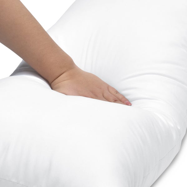 Weiches, weißes Kopfkissen wird mit der Hand eingedrückt