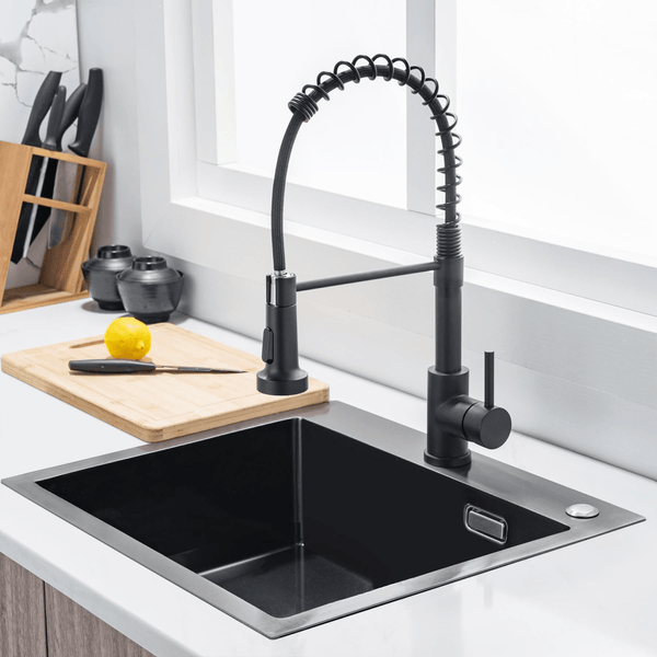 Moderne schwarze Küchenarmatur mit Profi-Spülbrause an einer schwarzen Einbauspüle in einer hellen Küche