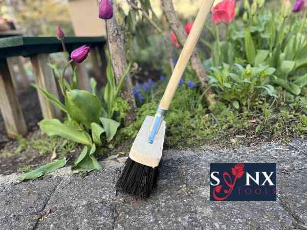 Besen mit Holzstiel im Gartenbereich