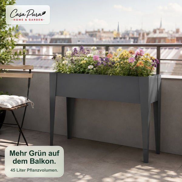 Modernes graues Hochbeet auf Beinen aus Metall auf einem Balkon, bepflanzt mit bunten Blumen vor einer Stadtkulisse.