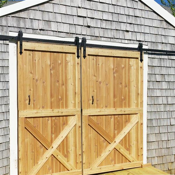 Holzschiebetor mit Beschlägen vor einem Gebäude