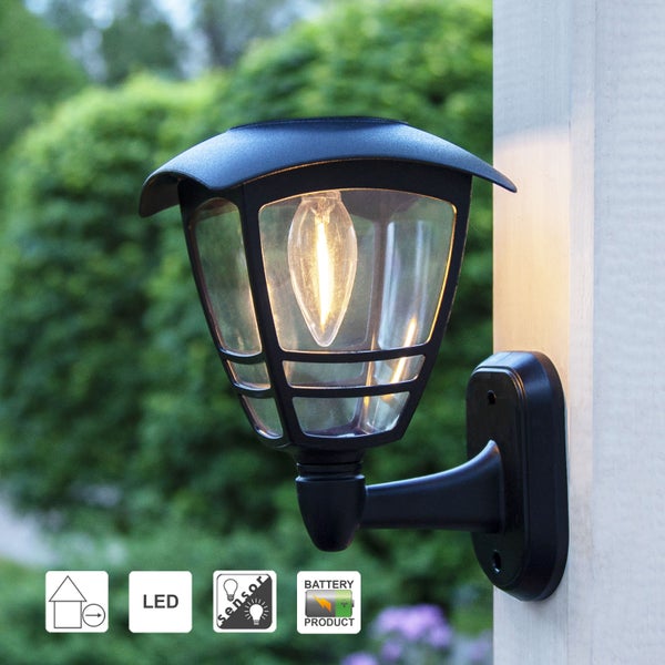 Dekorative Szene mit leuchtenden Papiersternen, Stuhl, Rahmen, Vase mit Eukalyptus und Kerzen für eine gemütliche Atmosphäre