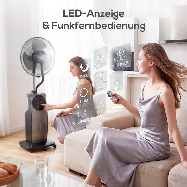 Moderner Standventilator mit Sprühnebelfunktion, digitaler Anzeige und Fernbedienung in einem hellen, organisierten Wohnzimmer mit einer Frau auf dem Sofa.