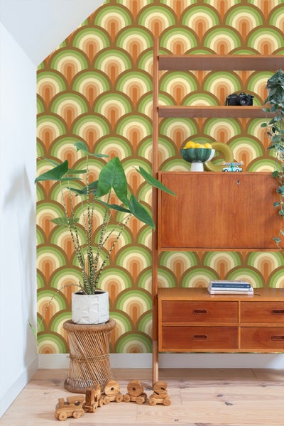 Retro-inspirierter Raum mit grafischer Tapete, Holzregal und Zimmerpflanzen