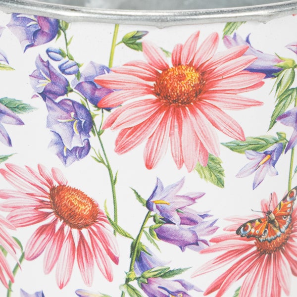 Nahaufnahme eines Metallpflanztopfes mit floralem Muster aus Sonnenhut, Glockenblumen und Schmetterling.