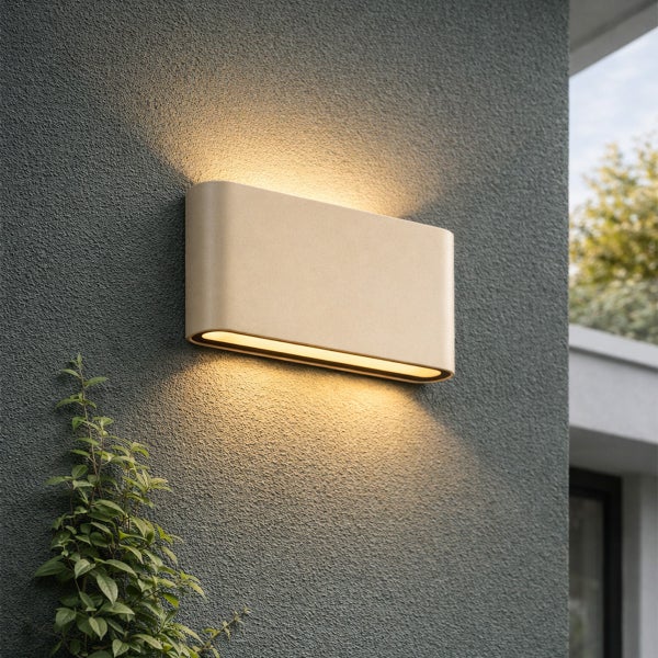 Moderne LED-Außenwandleuchte in rechteckiger Form mit abgerundeten Ecken, strahlt warmes Licht nach oben und unten an die Fassade.