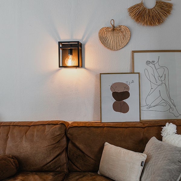 Wandleuchte aus Metall mit Glühbirne in Wohnzimmerumgebung