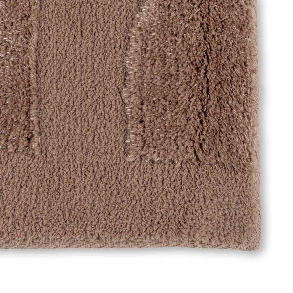 Nahaufnahme einer taupefarbenen Hochflor-Badematte mit strukturiertem Muster.